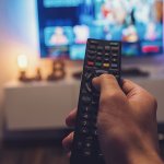 Male,Hand,Holding,Tv,Remote,Control.,Point,Of,View,Shot